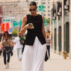 attendee of new york spring 2025 fashion week looking down at phone 