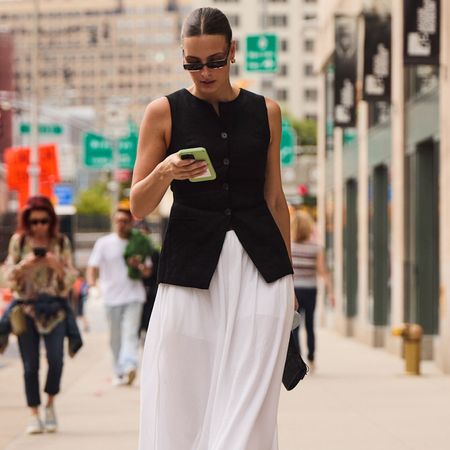 attendee of new york spring 2025 fashion week looking down at phone 