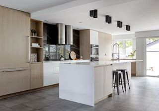A modern minimalist style kitchen with white island and white cabinetry