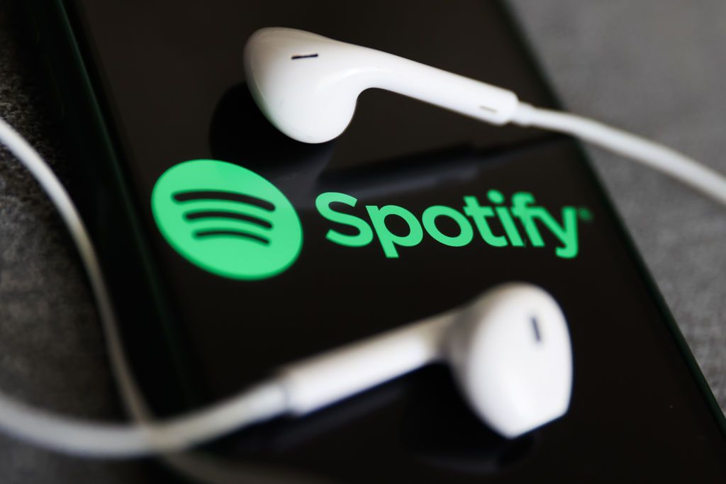 Spotify logo on phone screen with white earphones