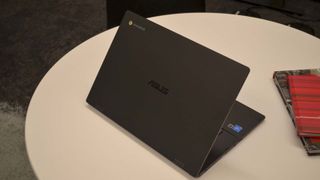 The half open lid of the Asus Chromebook CX1500 on a white table