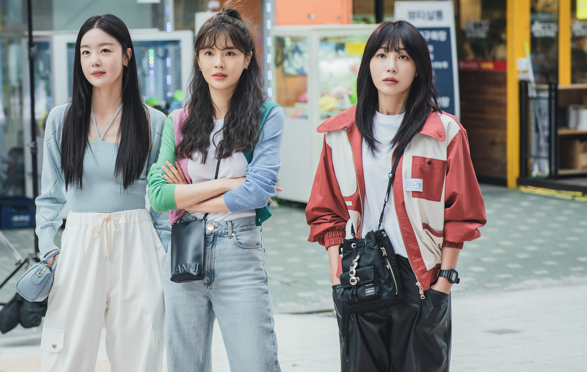 Three Korean women stand in an empty Seoul street, in a still from the K-drama 'Work Later, Drink Now.'