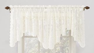 sheer ivory lacy valance over white window frame