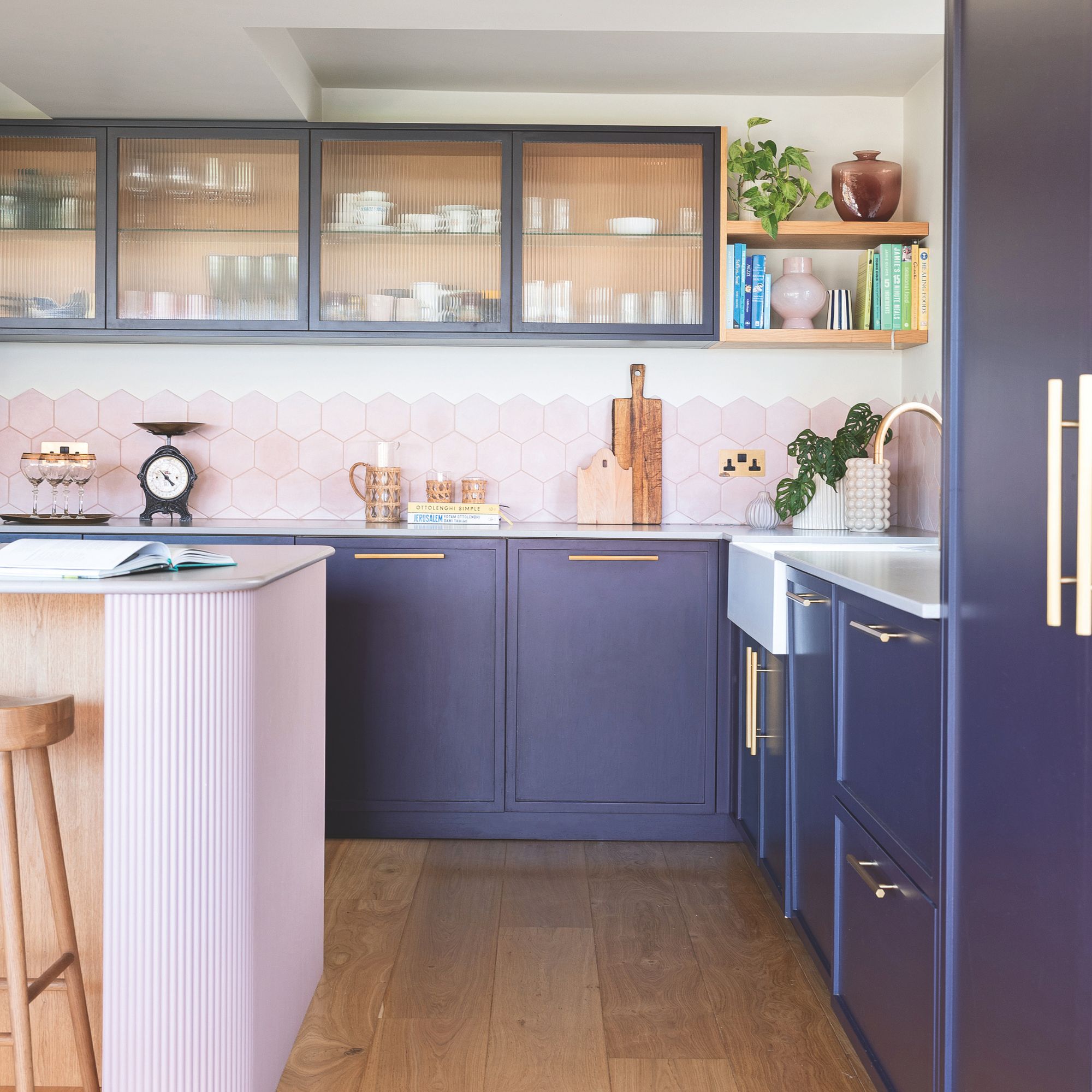 White painted kitchen with pink splashback tiles and blue kitchen cabinets