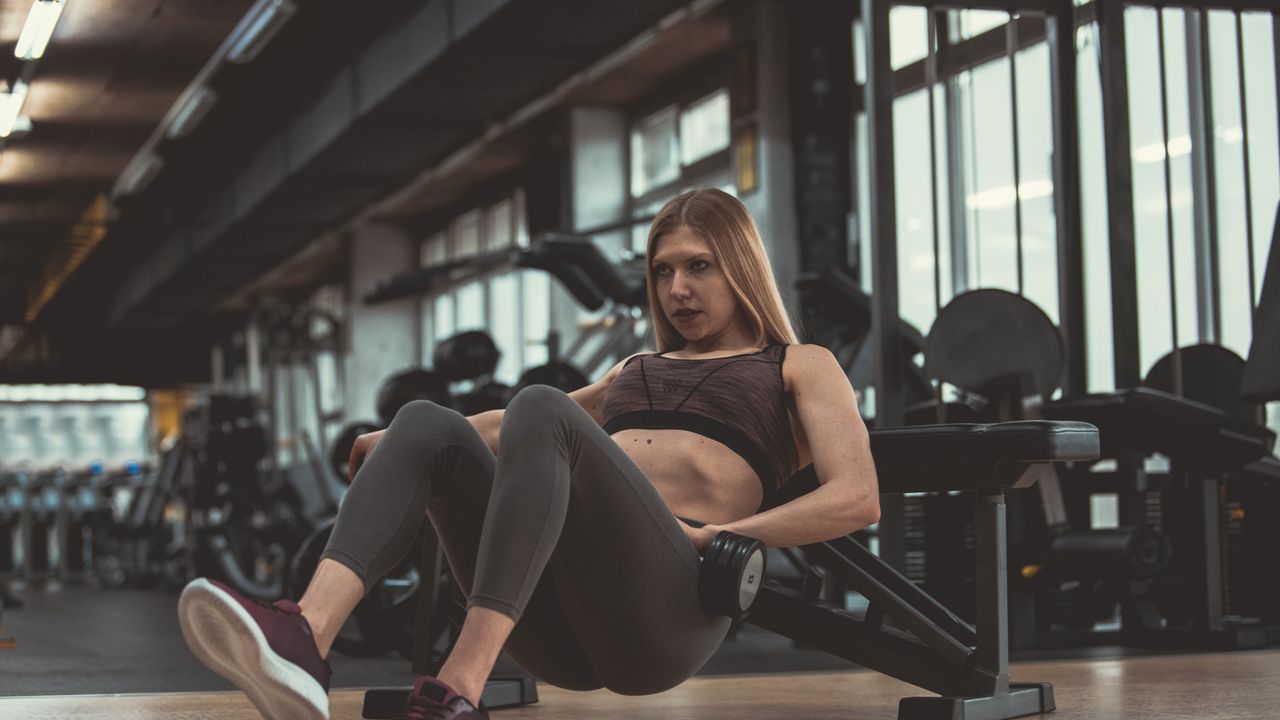 A woman setting up for a dumbbell hip thrust