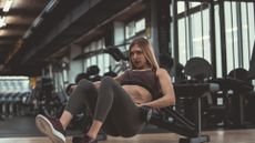 A woman setting up for a dumbbell hip thrust