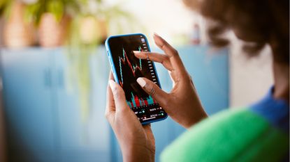 A woman uses her smartphone to check the trading status of her stocks.