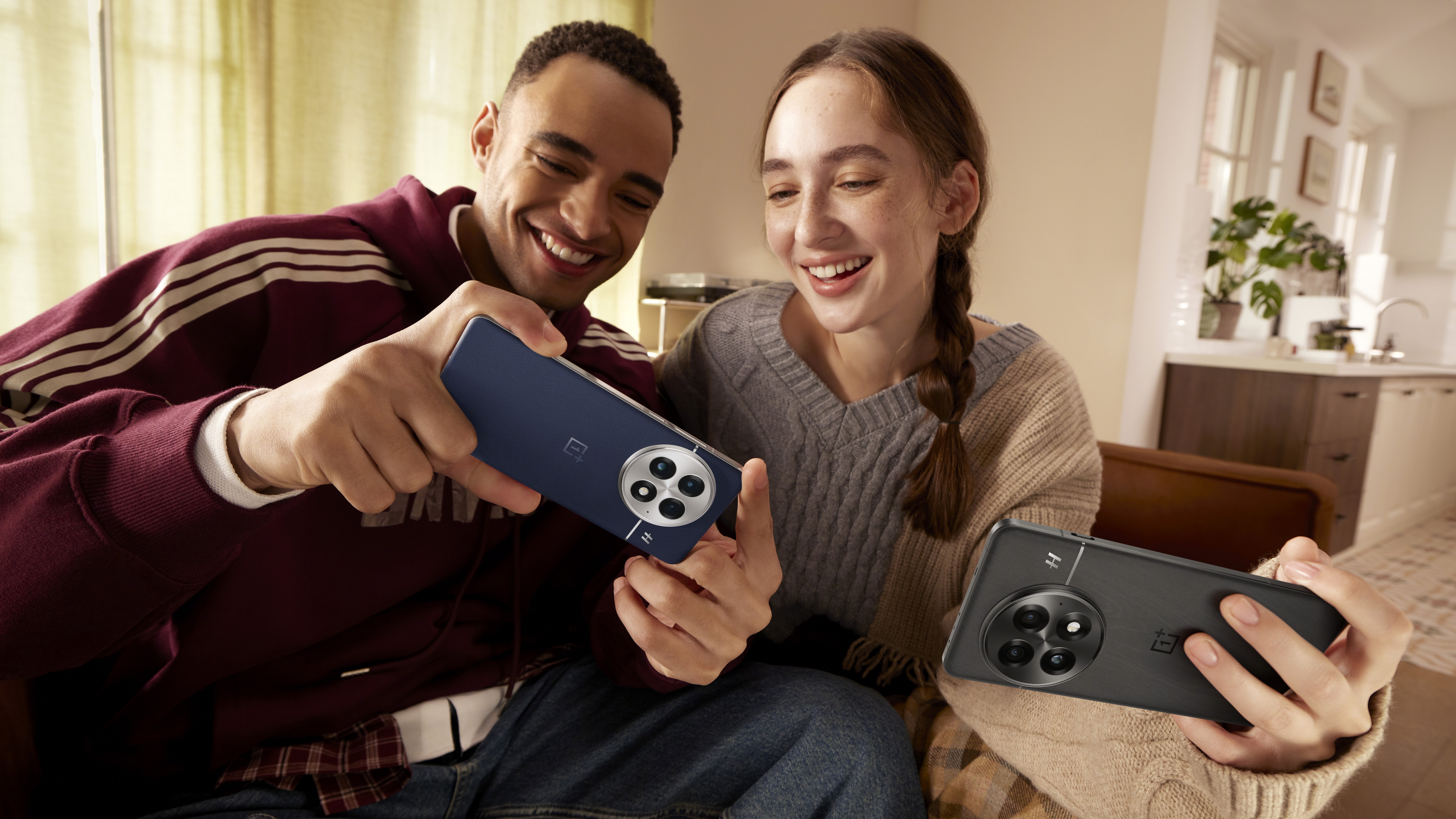 A man and woman holding two OnePlus 13 phones