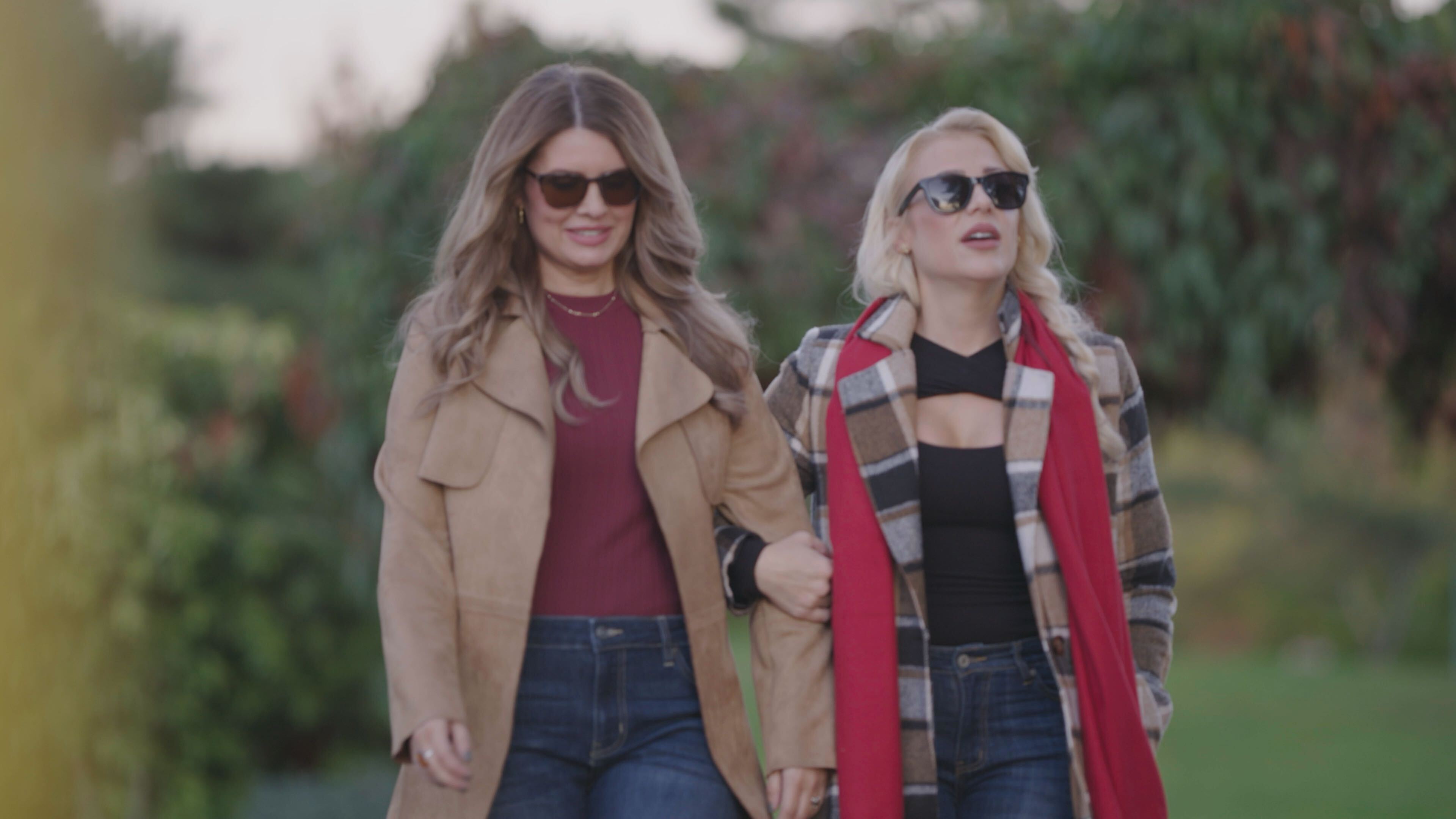 Amber and Athena wearing coats walking through a field in the true crime doc don't date brandon