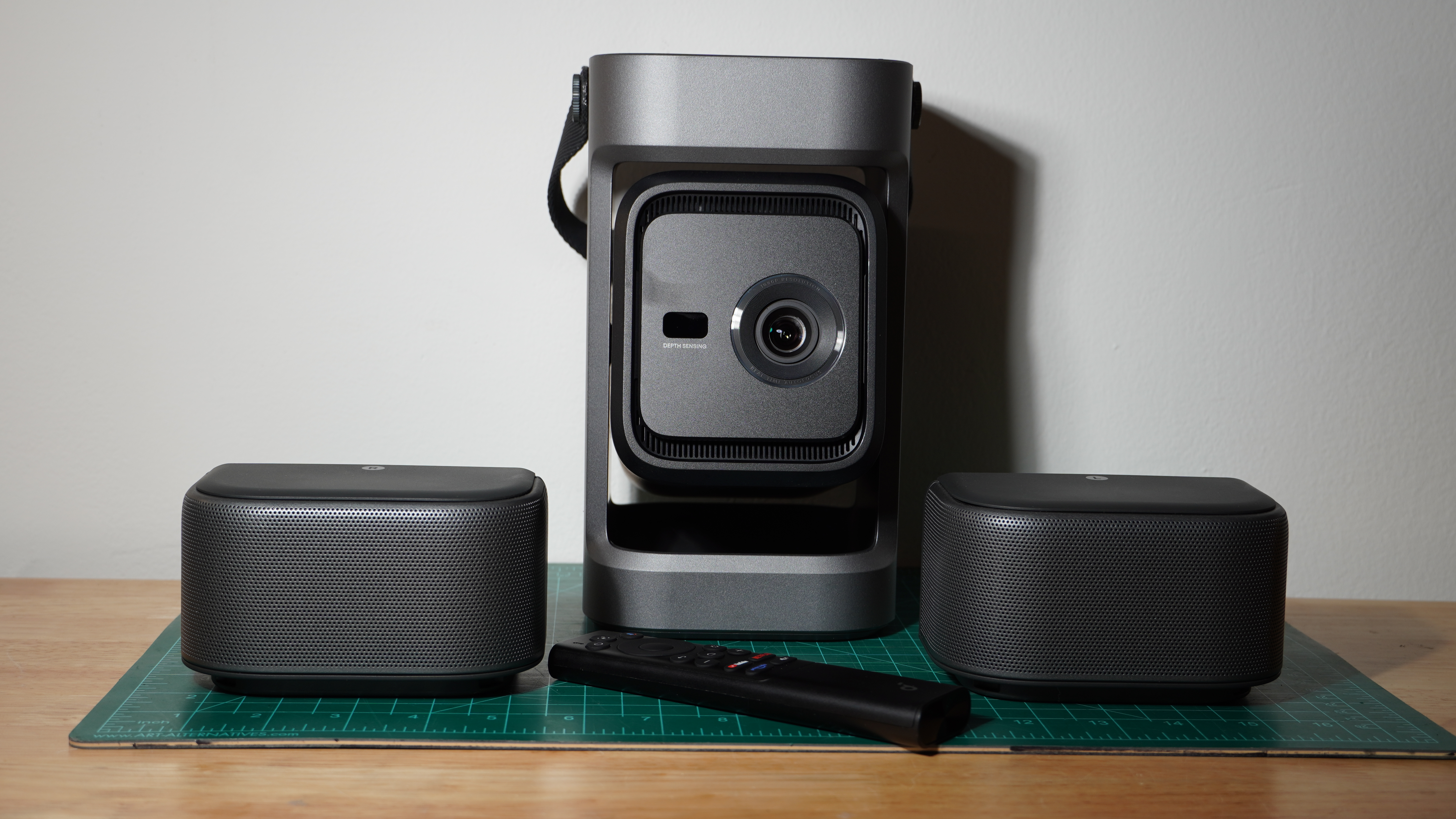The Soundcore Nebula P1 with its speakers pictured on a wooden surface against a white background