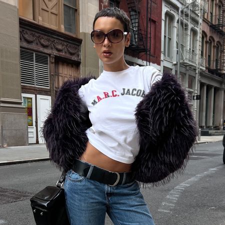 @aishafarida wears bootcut jeans with a graphic tee and a fur jacket