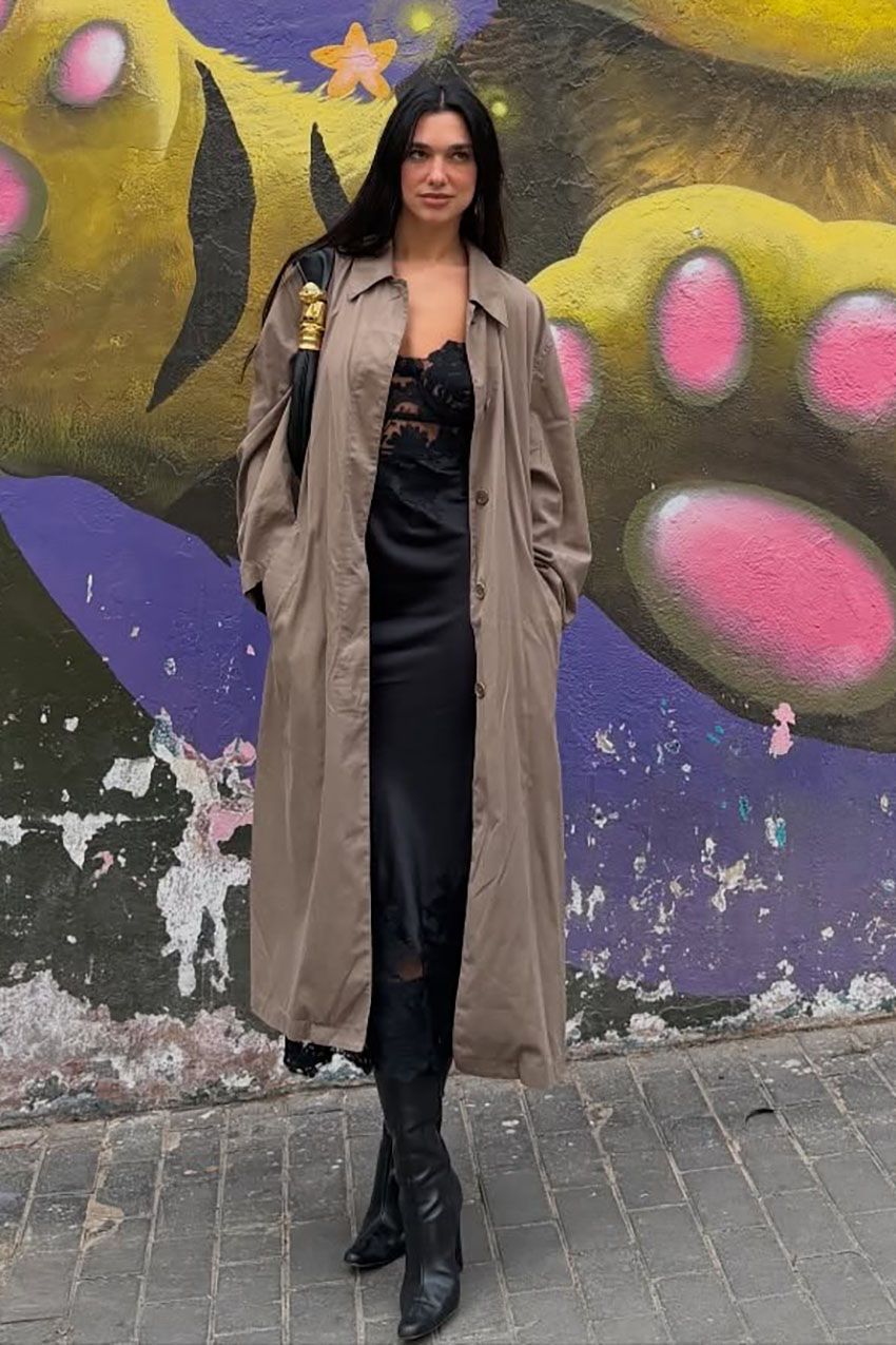 dua lipa wearing a trench coat and black satin dress