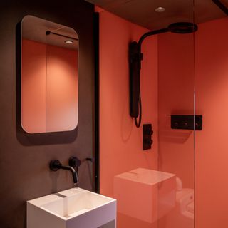 A modern red shower room within a small cabin