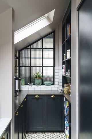 nearly black small kitchen with crittall style window and patterned floor