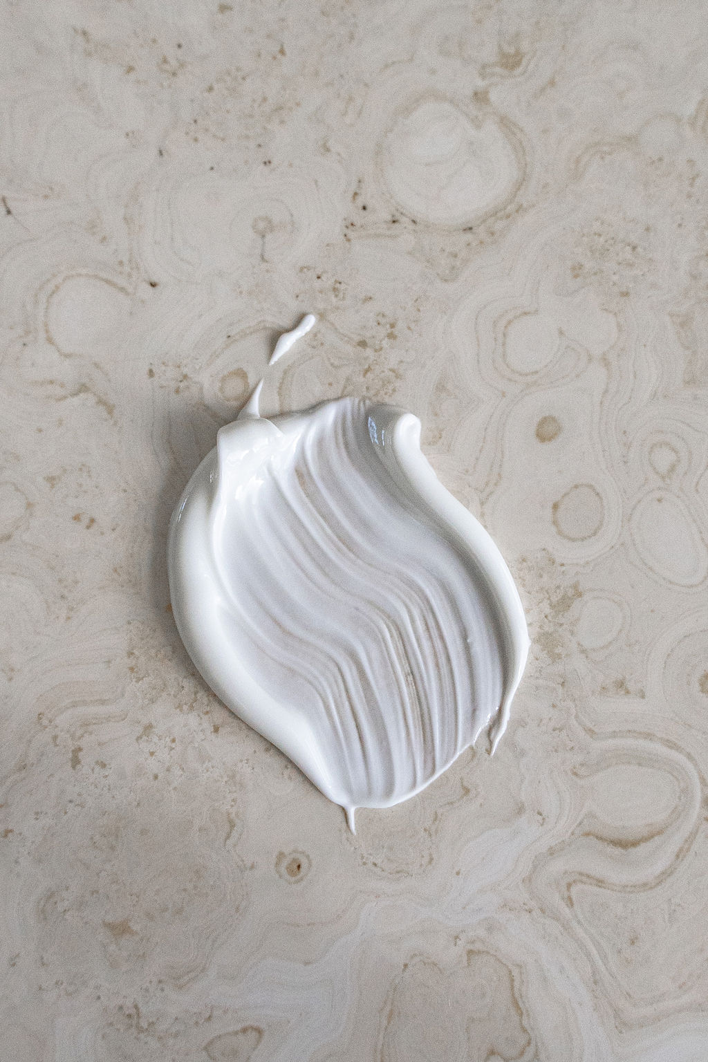 Image of lotion smeared on a stone surface.