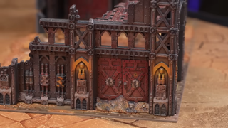 A prepainted Warhammer terrain piece on a dusty battlefield board
