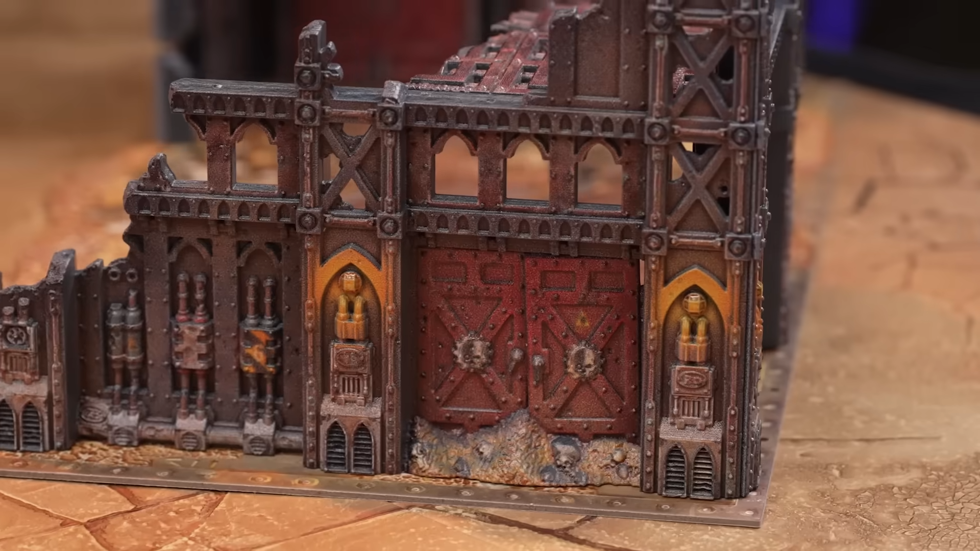 A prepainted Warhammer terrain piece on a dusty battlefield board