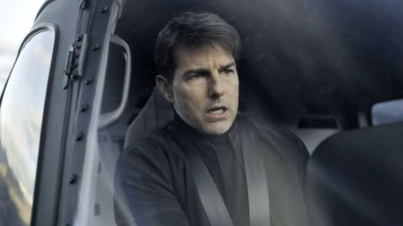 Tom Cruise, dressed in nothing but black sits behind the controls of a helicopter for Mission: IMpossible - Fallout (2018).