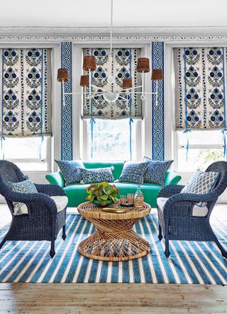 Blue rattan chairs and a green sofa in a living room