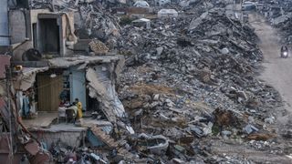 Tamer Hassan al-Shafei and his family sit for an evening meal during Ramadan in the remains of their home, overlooking the ruins of Beit Lahiya in the Gaza Strip on March 4, 2025.
