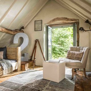 den with open door wooden bed sofa chair and wooden flooring