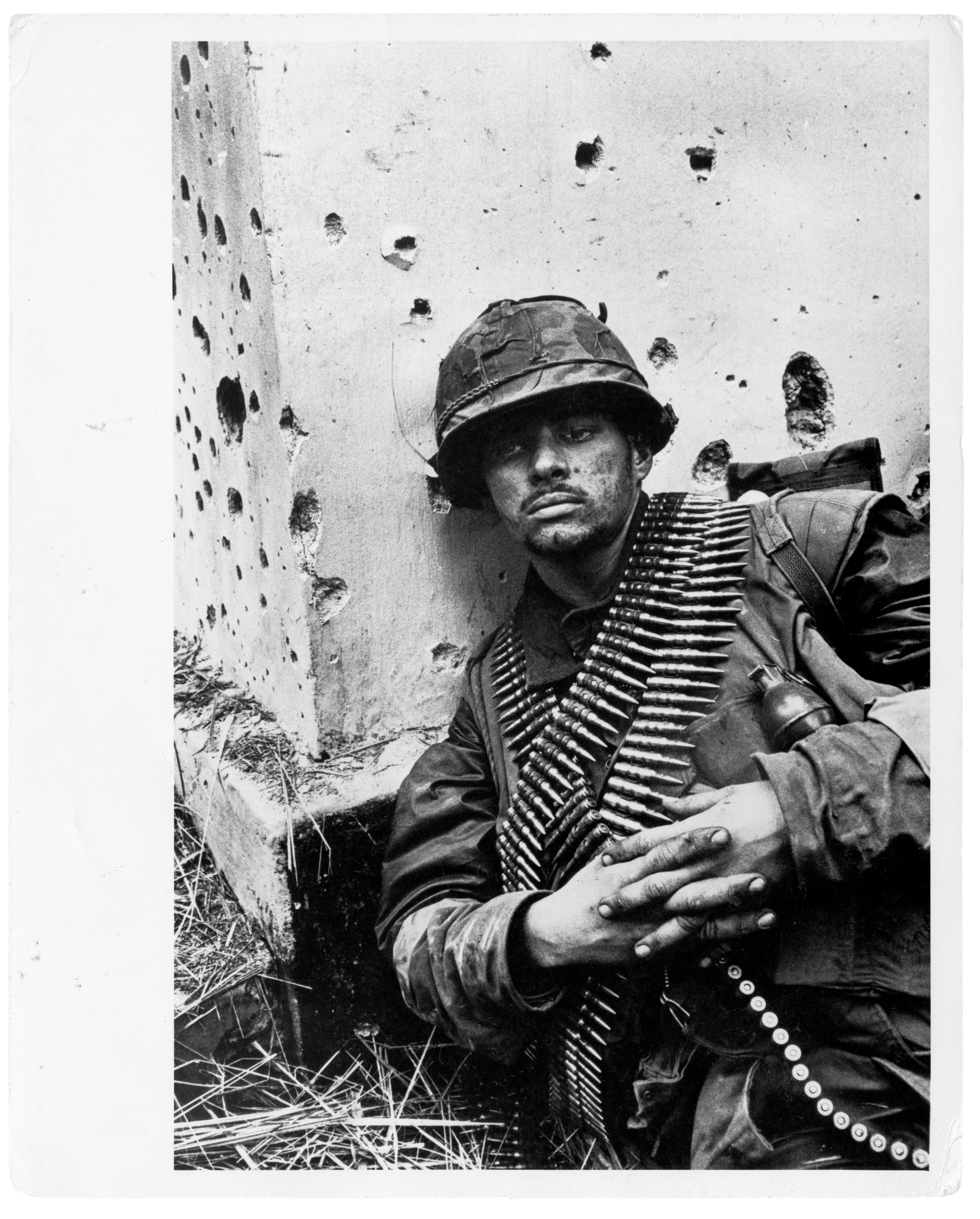A solider sits dazed against a wall