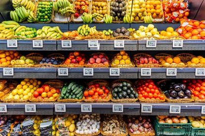 Shelves in a grocery store filled with vibrant fruits and vegetables.