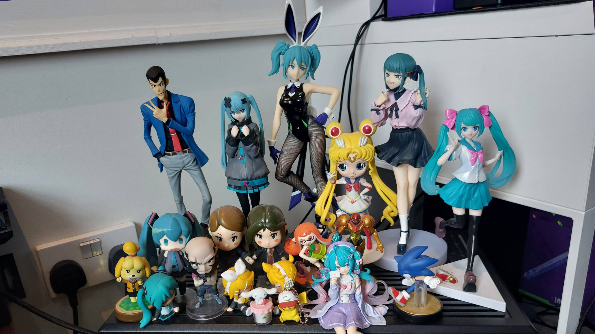 A PC with many anime figures placed inside. It looks quite crowded and impractical. The RGB lighting really makes it pop though.