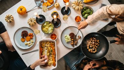 Several people sitting at a table serving up vegan and vegetarian food