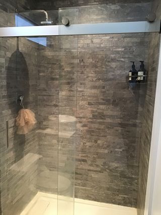 A dated shower with stone effect tiles