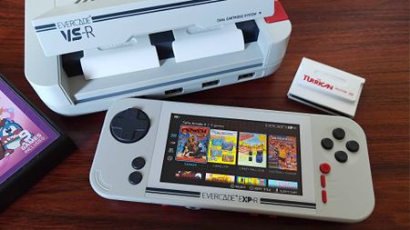 Evercade EXP-R handheld in front of Evercade VS-R console on woodgrain desk.