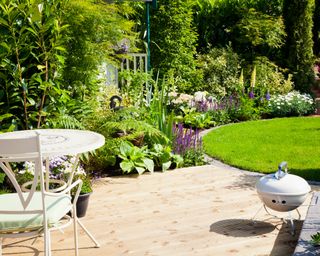 A landscaped backyard with small decked bbq area