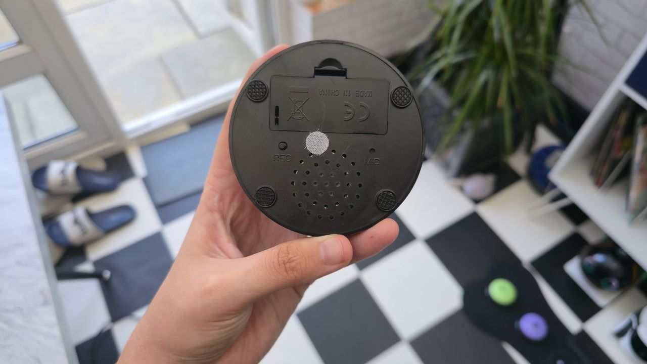 Beth's hand holding the underneath side of a talking pet button
