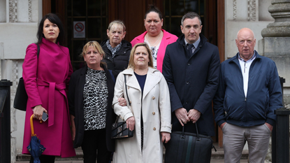 Relatives of people killed during the Troubles stand outside Belfast's High Court 