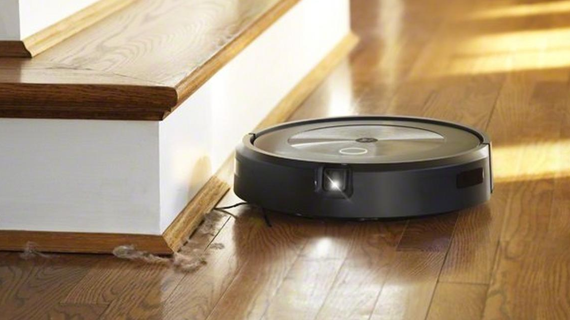 L'aspirateur iRobot Roomba série J AI par un escalier en bois.