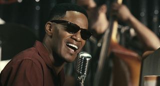 Jamie Foxx wears shades as Ray Charles singing into a microphone in 'Ray'