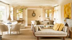 living room with cream walls and sofas and view of staircase