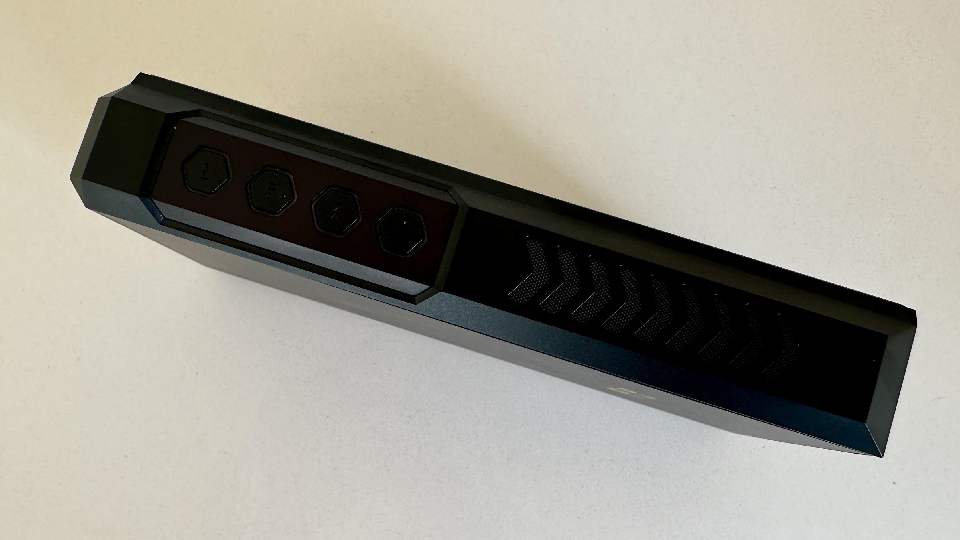 The FiiO M27 player with screen and dial showing, and content on the screen, on beige or yellow background