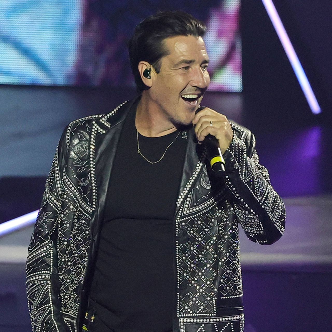 Jonathan Knight of New Kids on the Block singing into a microphone