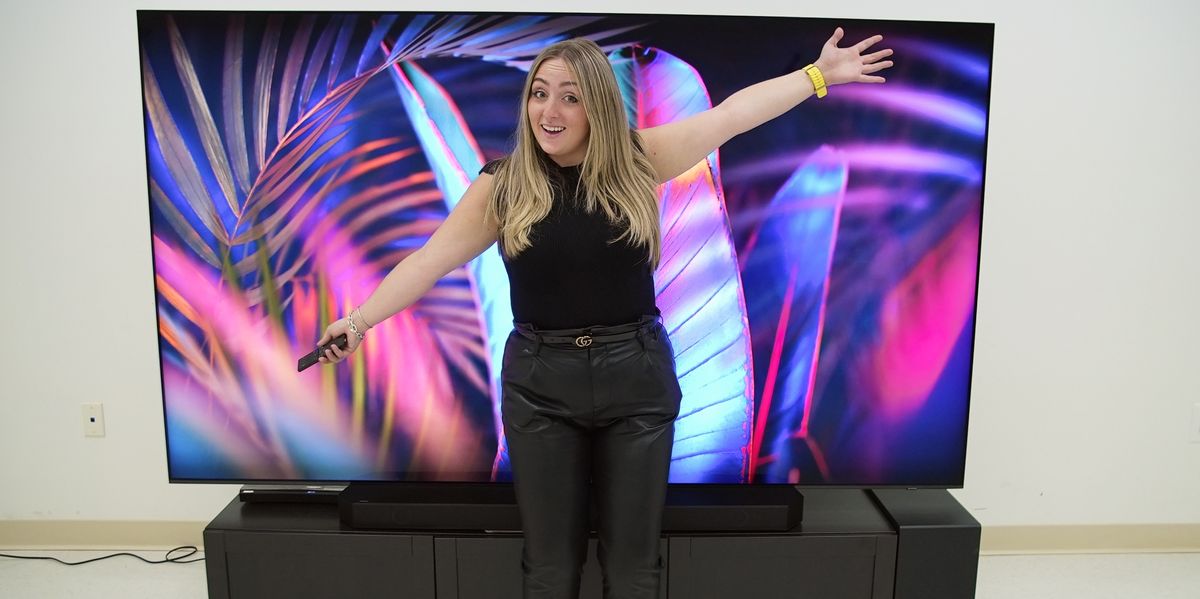 woman standing in front of Samsung QN100B Neo QLED TV