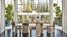 Dining table by large windows overlooking garden