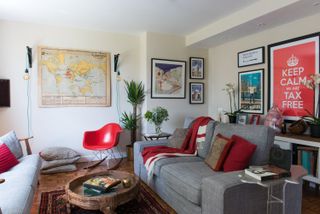 a cosy living room with a grey sofa, gallery wall, red rocking chair and a cosy rug