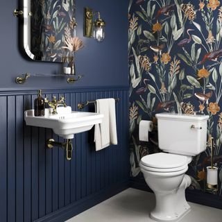 dark blue bathroom with white sanitaryware and brass fixtures