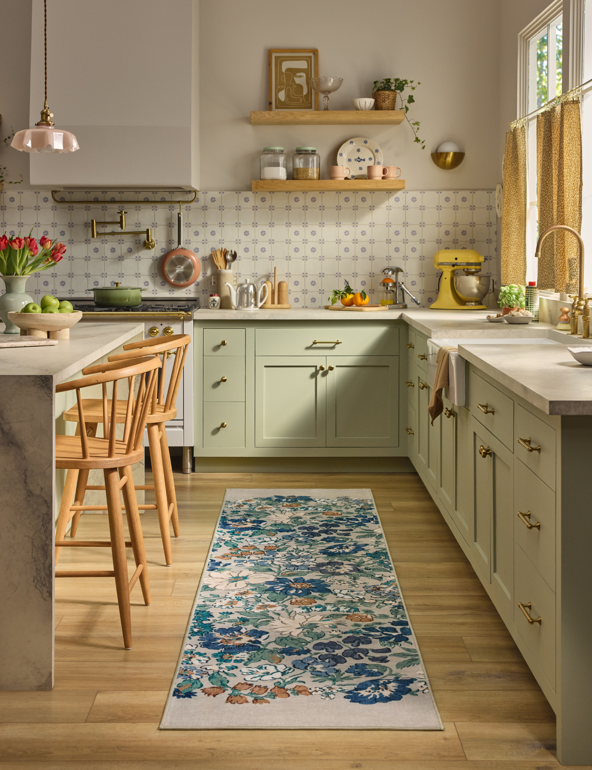 Bright kitchen featuring light wood florals, pale green cabinetry, and a floral runner rug.