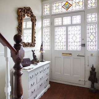 white hallway with drawer and wall mirror