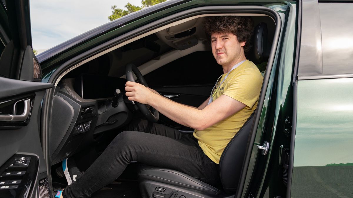 Driver sitting in driving seat of blacked out Kia EV6