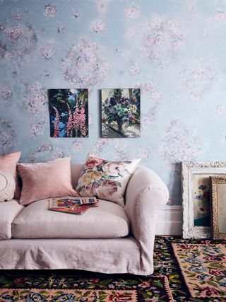 floral wallpaper in living room with pink sofa and cushions