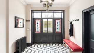 hallway with patterned floor tiles and stained glass front door