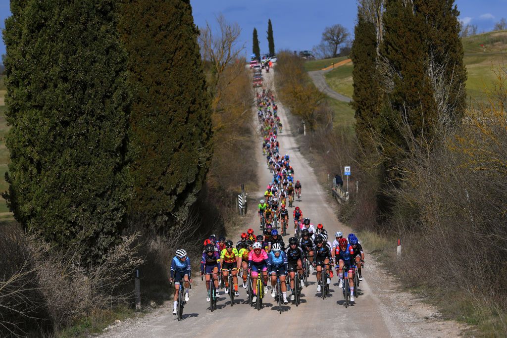 The Strade Bianche Women's peloton is lined out on a descent