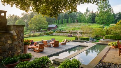 How much does landscaping cost, illustrated in a backyard with water feature and patio areas, terraces, lawn and a wild meadow garden.